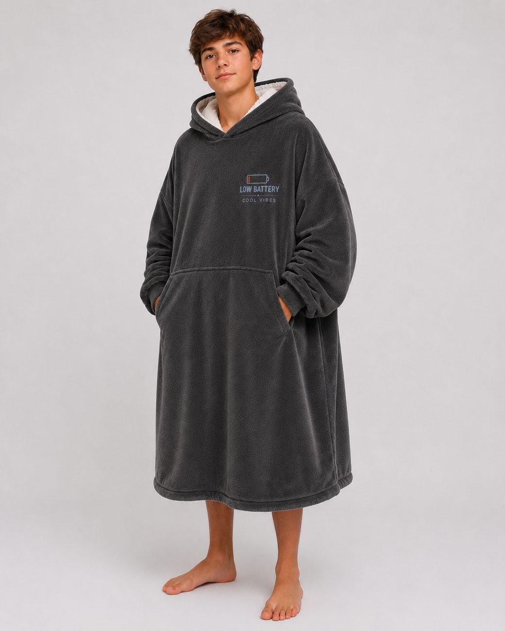 The Low Battery Recharge Hoodie Blanket worn from the front, hands in the kangaroo pocket, hem falling past the knee.