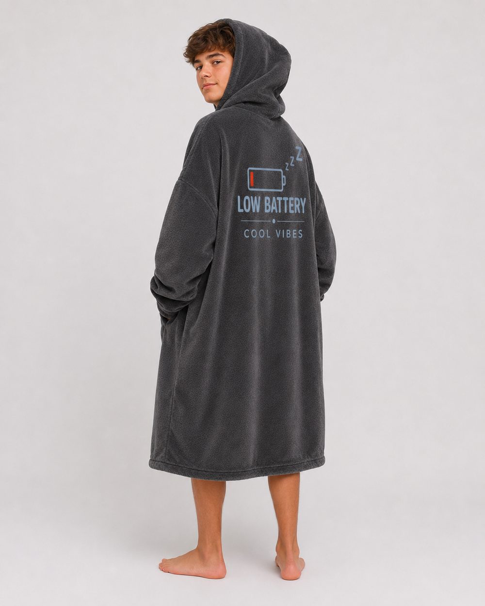 The Low Battery Recharge Hoodie Blanket worn with the hood up, seen from behind, showing the full artwork across the back.