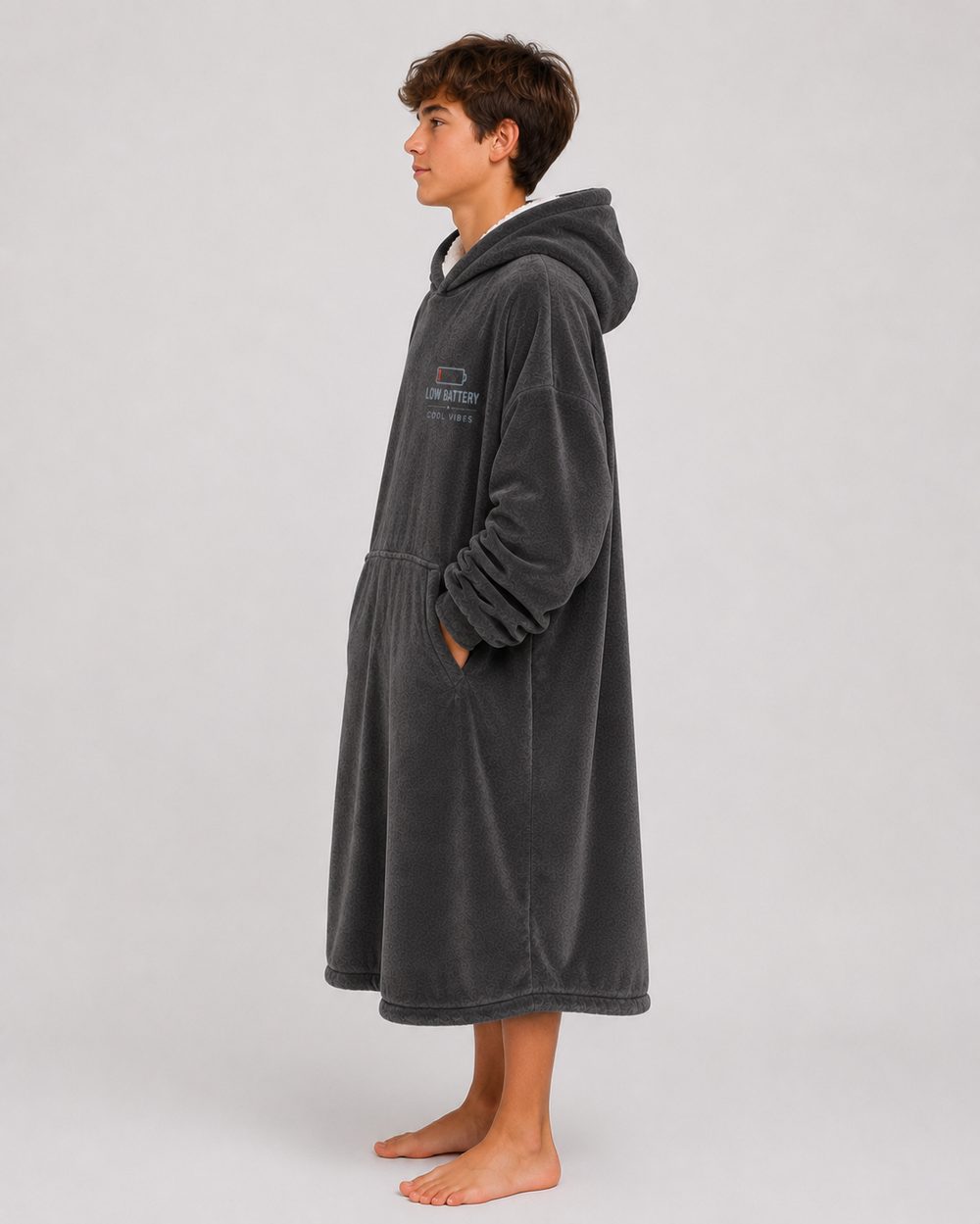 Side profile of the hoodie blanket showing the drop of the hem and the volume through the body and sleeves.